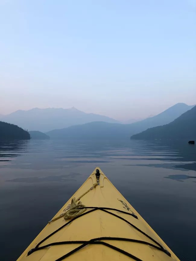 Kayaker on a North Cascades lake with mountains in the distance